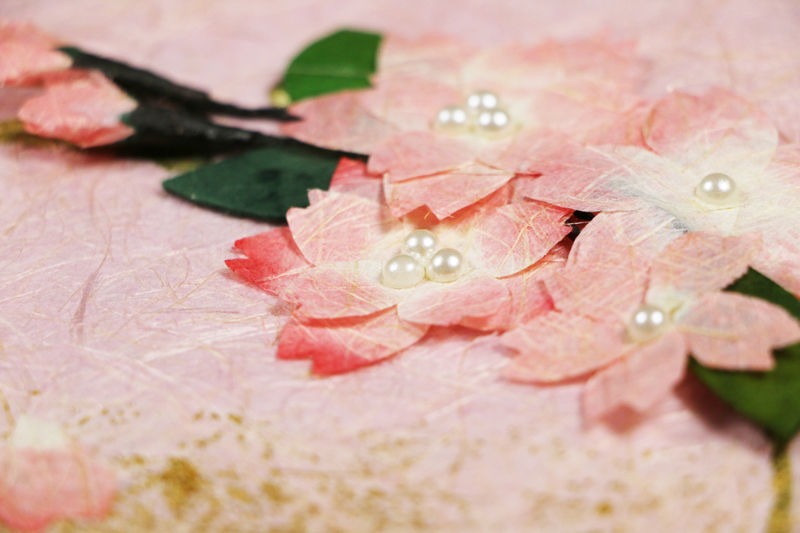 ピンク色に染色した和紙に、立体的な桜飾りを配置した創作デザイン和紙（デザイン部分アップ）